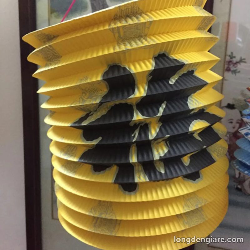 Lồng đèn ống giấy xếp vàng in chữ Hán
